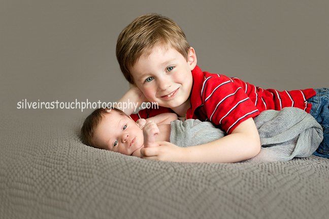 brothers smiling at newborn session