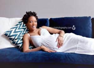 Edisonnjmaternity pregnancy mom smiling at camera while on couch laying