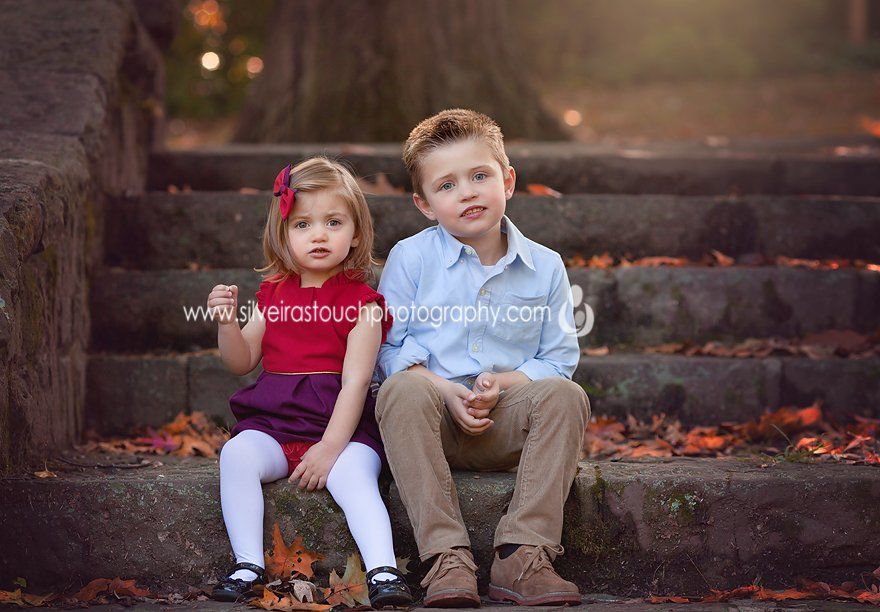 outdoor photo of children sibling sitting on steps at Nutley NJ park