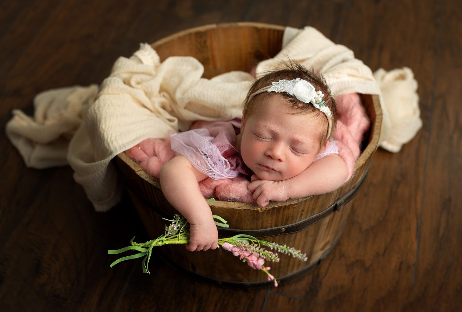 mount olive nj newborn portrait studio newborn girl sleeping in bucket holding pink floral taken at Mount olive NJ portrait studio by Silveira's Touch Photography