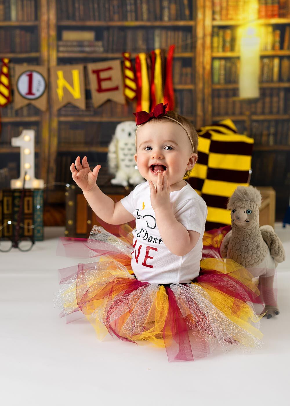 NJ Cake smash photo shoot Harry Potter baby girl wearing tutu in a Harry Potter theme smiling and clapping