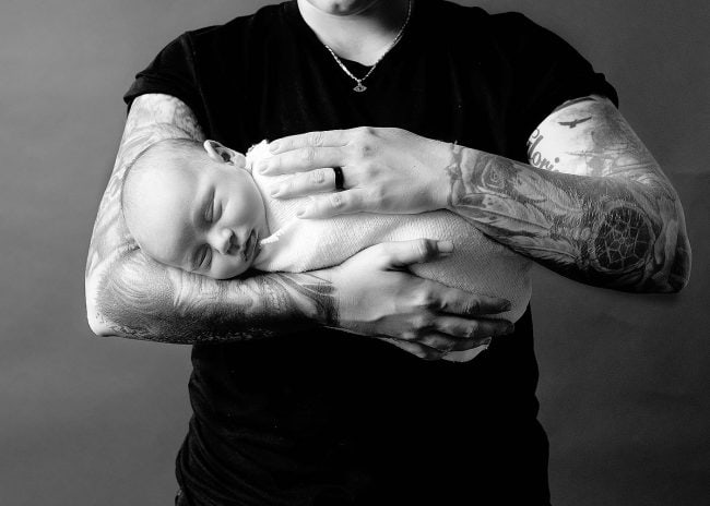 LGBTQ two moms holding baby boy while asleep in arms