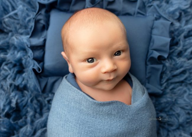 Baby boy wide awake for newborn photoshoot with two moms