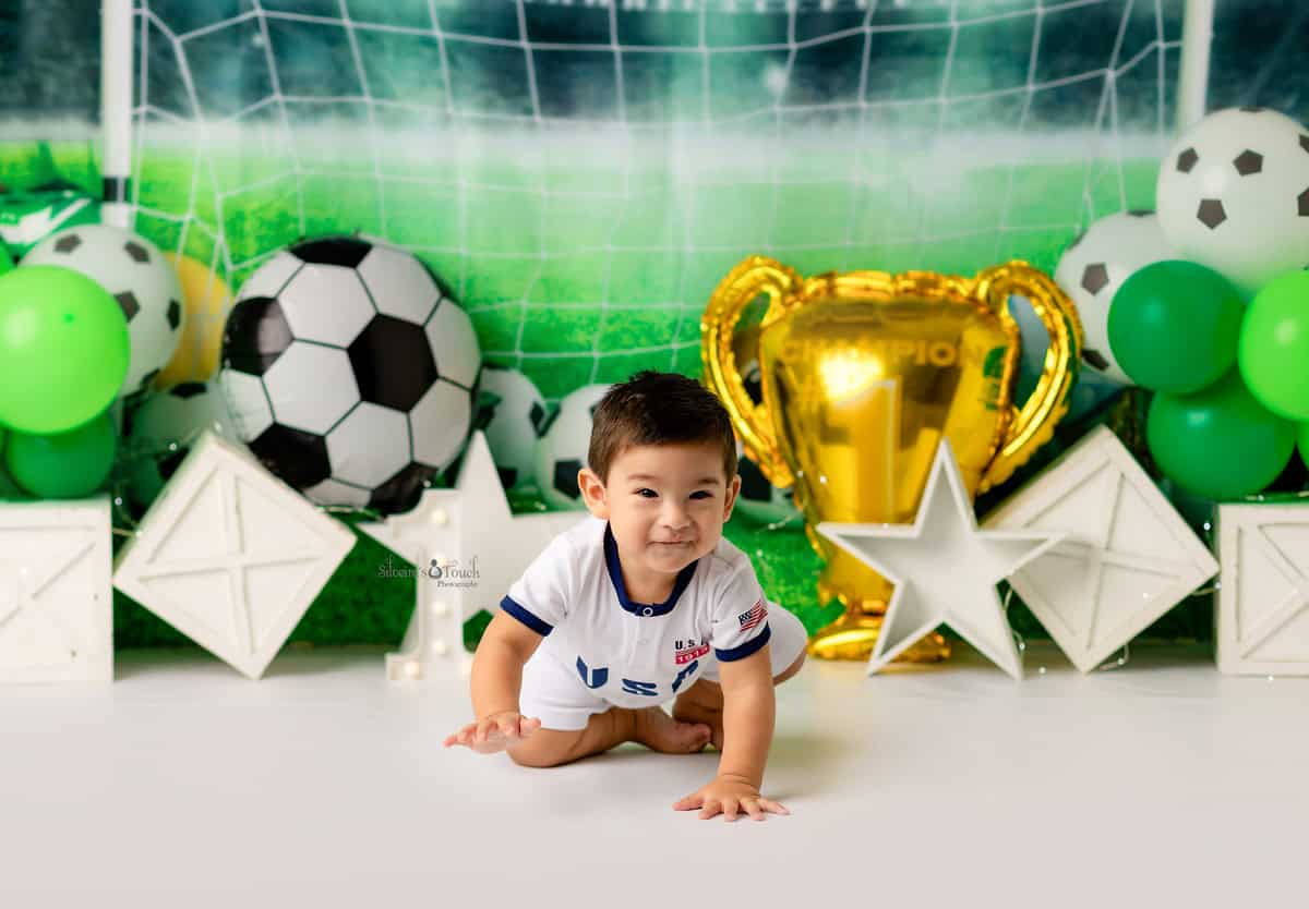 baby crawling on his Soccer Theme Cake Smash phot shoot in Randolph NJ studios