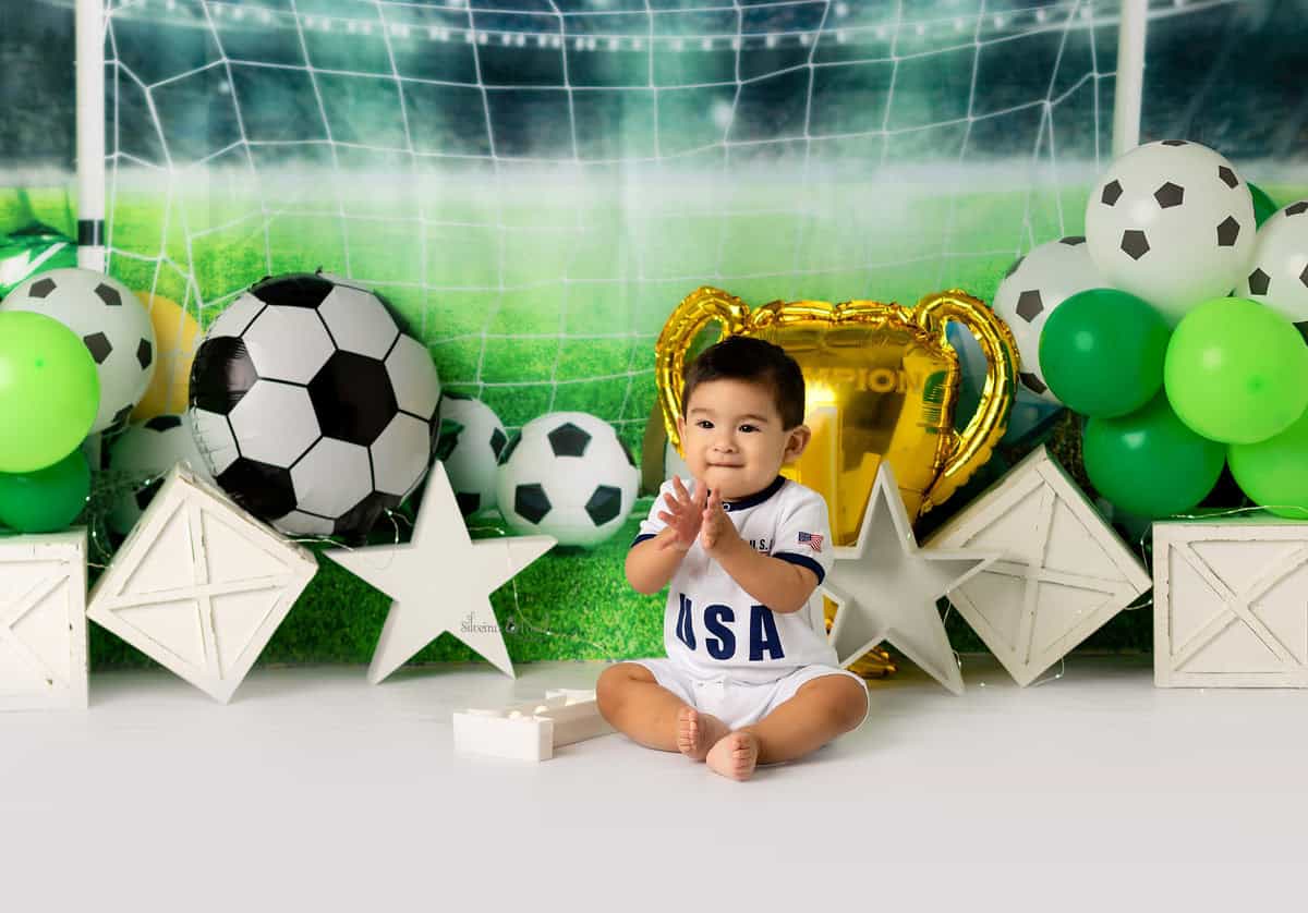 Baby boy clapping and smiling for his Soccer Themed photography session