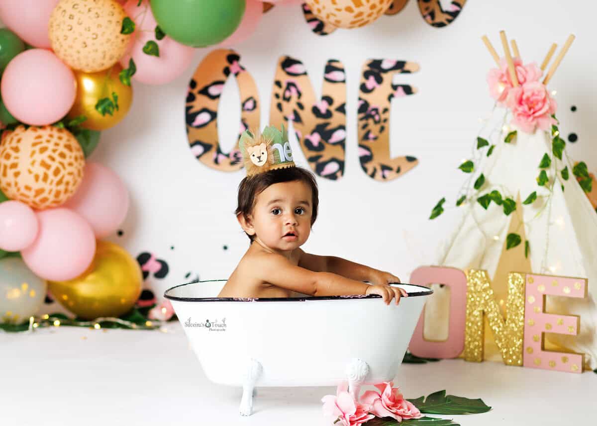 Baby laughing in a mini bathtub during post cake splash session