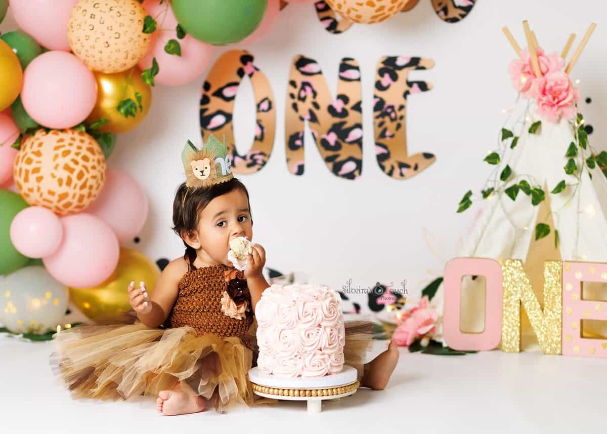 One year old baby girl covered in frosting during a safari wild one Cale smash photoshoot