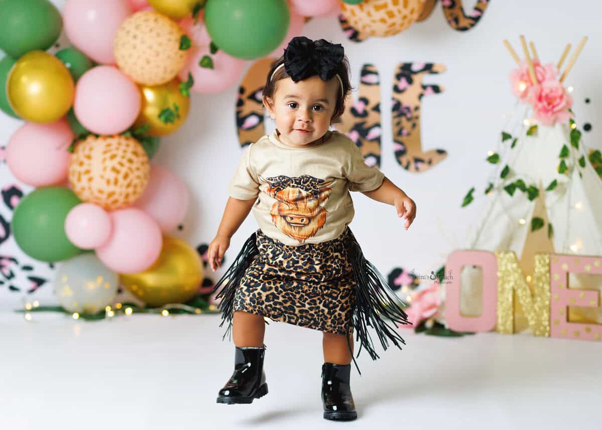 wild one birthday theme of baby wearing a cow girl dress