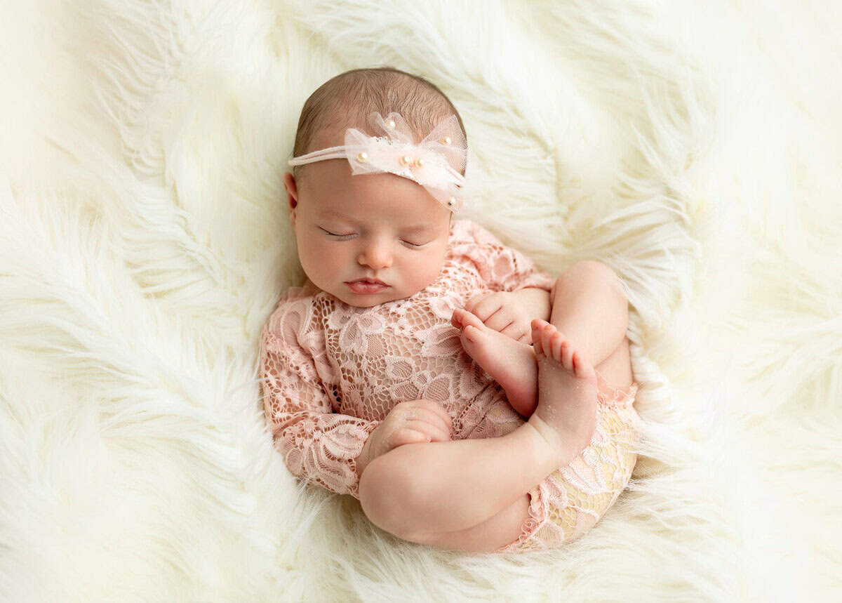 Tiny baby girl in a pink pearl headband captured in Mount olive NJ by Silveira's Touch Photography